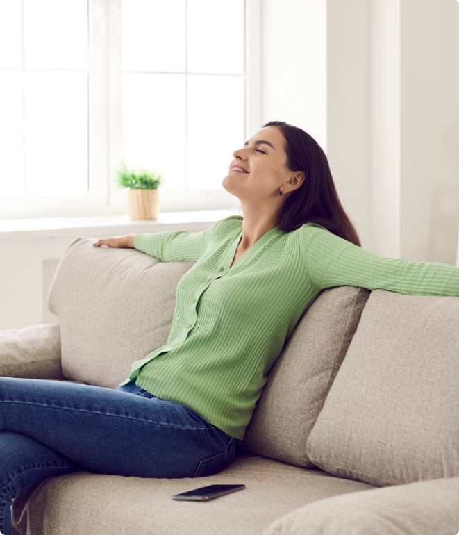 Woman relaxing on couch happy to have humidifier installation.