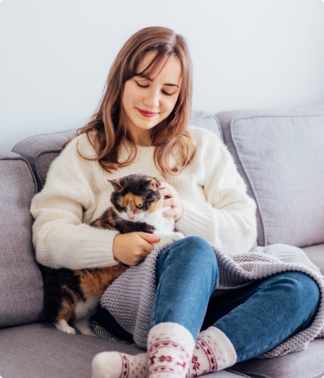 Woman cuddling her cat in her home, happy with her boiler repair in Kendallville, IN.